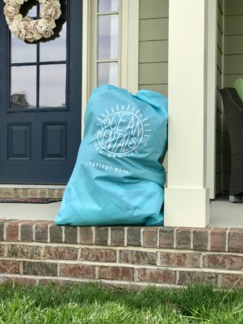 bedding and linen bag sitting on the front porch